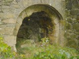 The rim of an old iron wheel has been cemented into the arch for strength